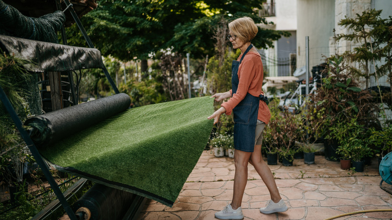 Female florist rolling out fake grass