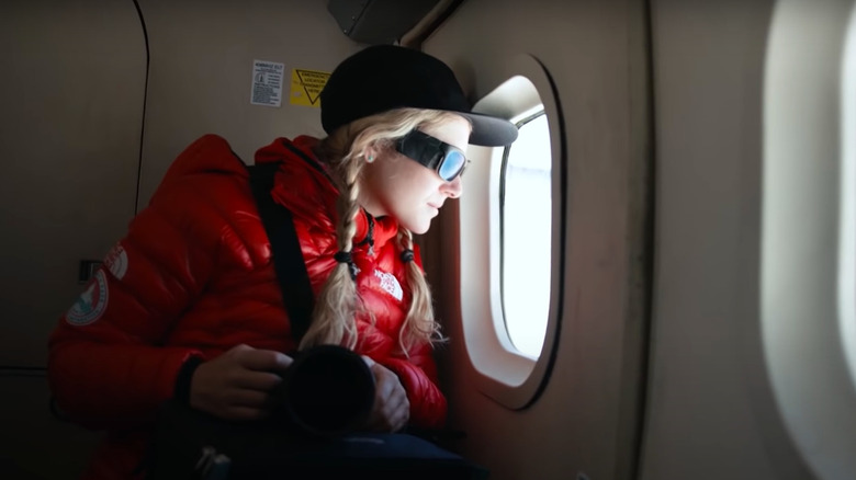 Woman wearing North Face jacket looking out of airplane window