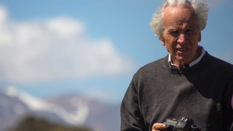 Douglas Tompkins holding camera and posing in nature