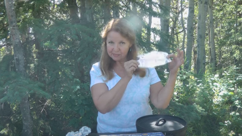 Woman holding up aluminum foil to reflect sunlight