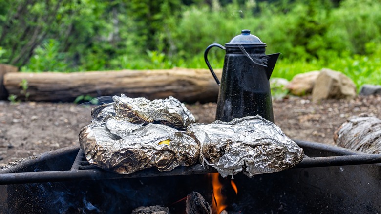 Tin foil pack and kettle over campfire grill