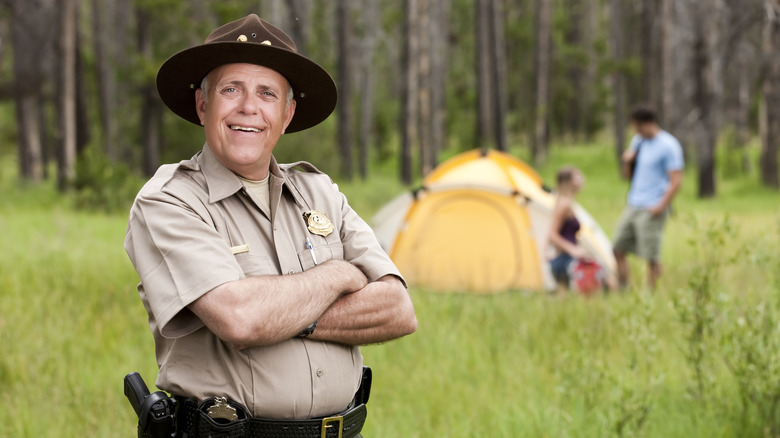 Happy ranger with campers in background 