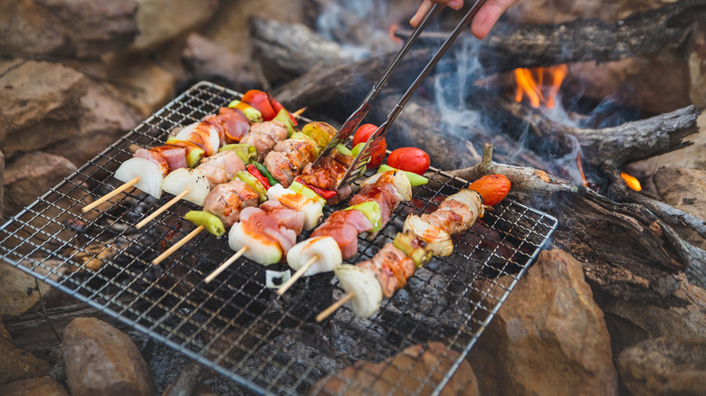 Grilling chicken kebabs outdoors