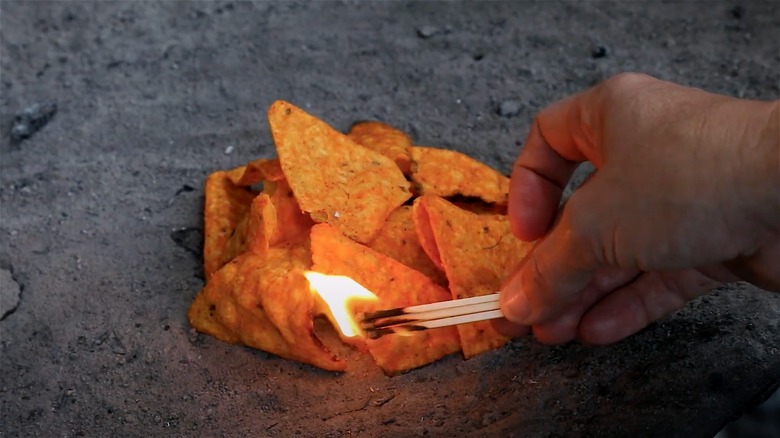 Person lighting Doritos with matches