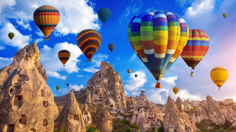 Hott air baloons float over Cappadocia cliffs