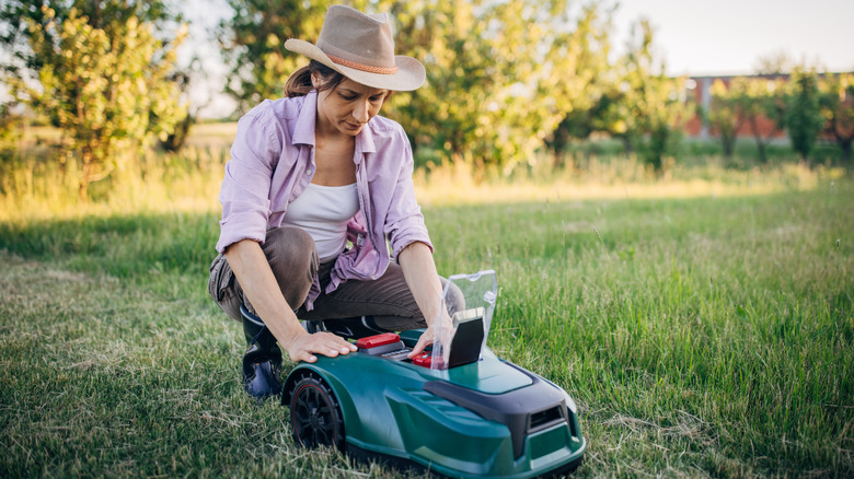 Female farmer preps her robot lawn mower