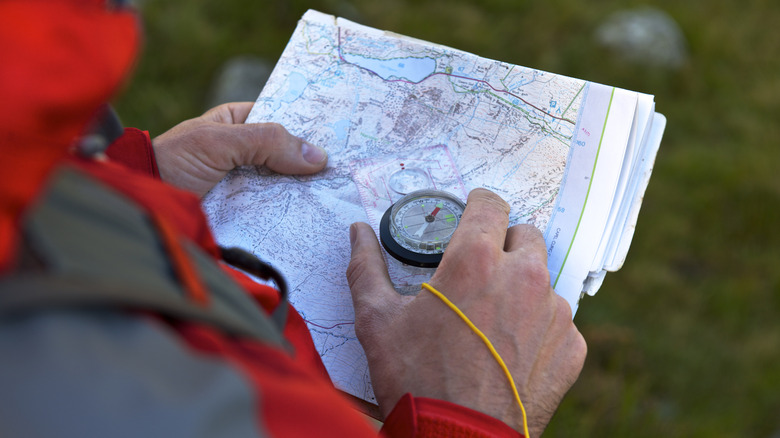 Hands holding map and compass