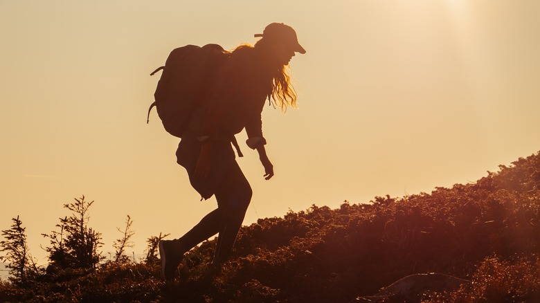Female hiker walking at sunset