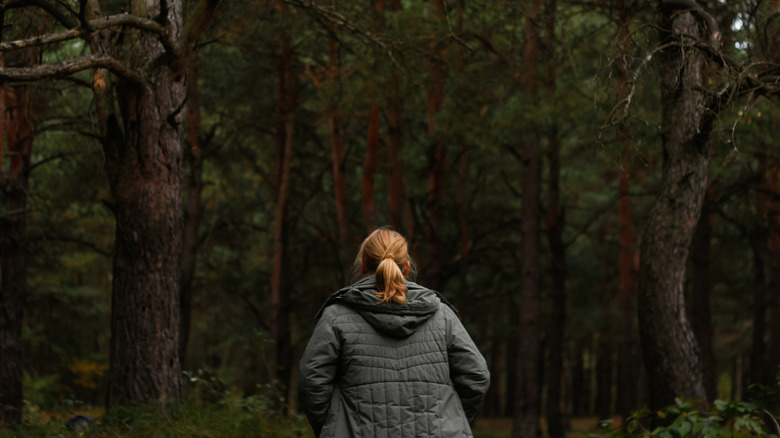 Lost female hiker looking at forest