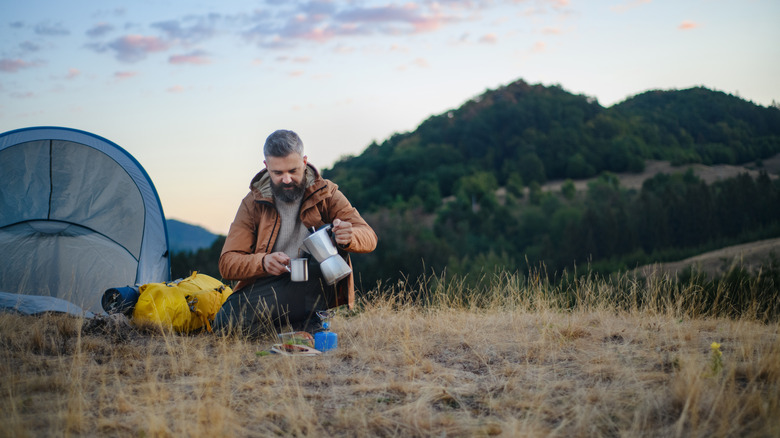 Backpacker at camp with a moka pot