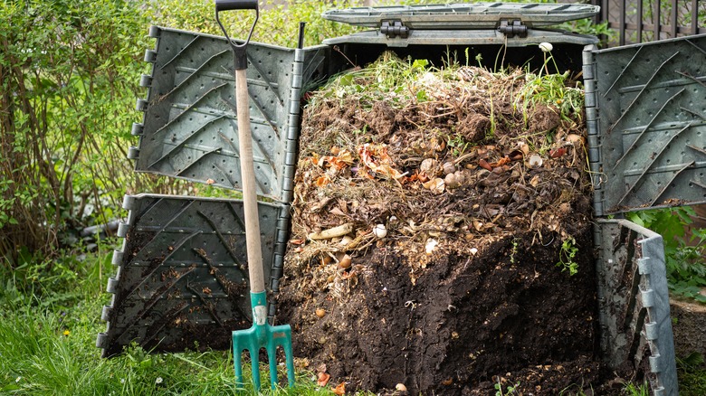 Garden fork next to a compost pile 