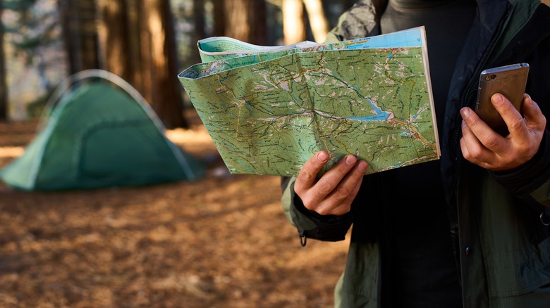 Hiker holding map and phone