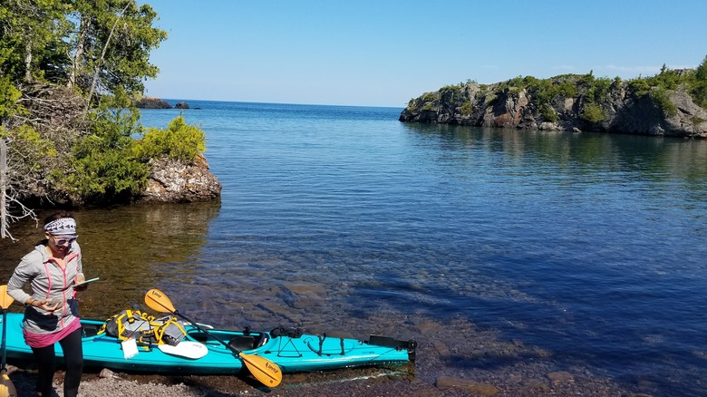 person by canoe on lake