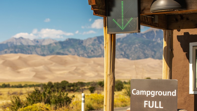 Campground full sign with mountain range in background