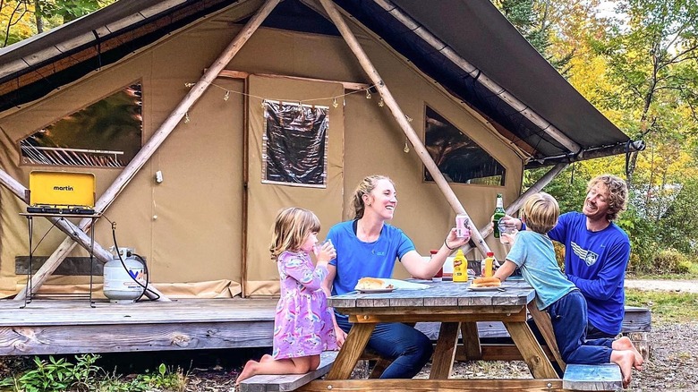 Family outside a Huttopia Cabin