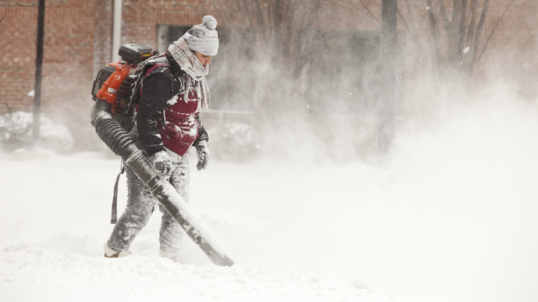 Person with leaf blower removing snow 