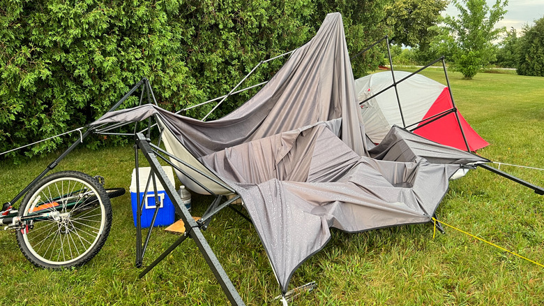 Broken tent on a grassy campsite