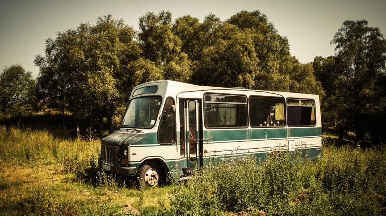 Abandoned minibus in field