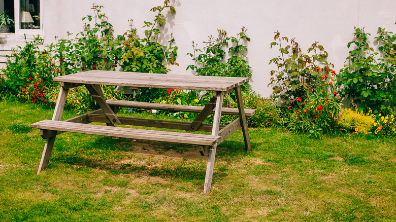 Picnic table in a garden in front of a flower bed