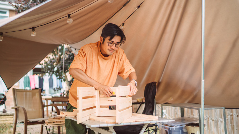 Man tackling a DIY table project in yard