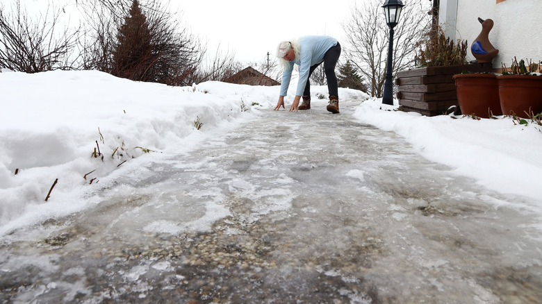 Person touching icy sidewalk