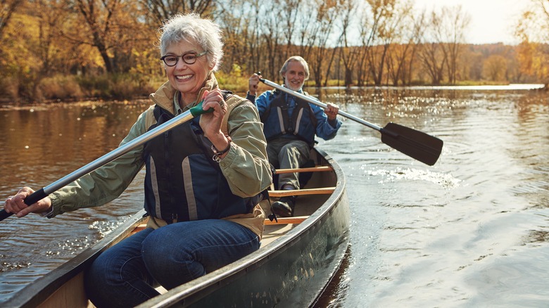 Happy elderly couple canoeing in lake