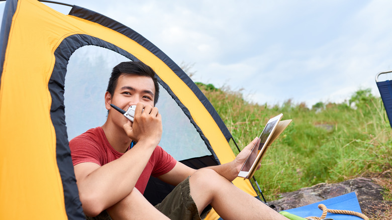 Camper speaking into handheld radio