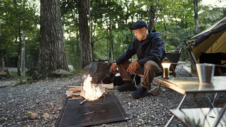 Solo camper seated at campfire