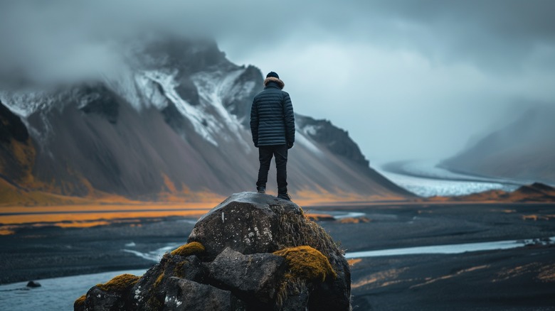 Solo traveler standing on rock looking at view in Iceland