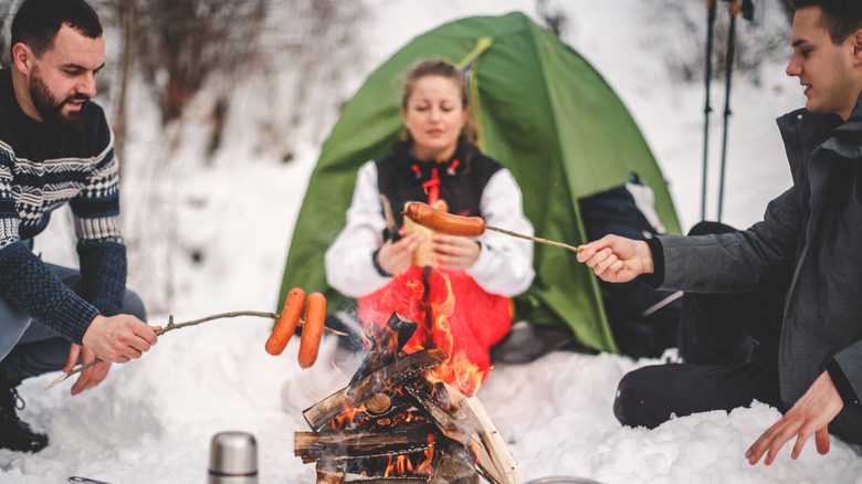 Winter campers cooking over a camp fire