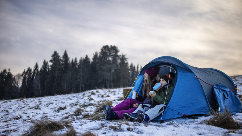 Young kids sheltered in a tent in the snow