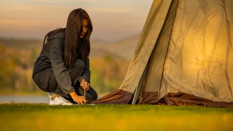 Woman staking tent