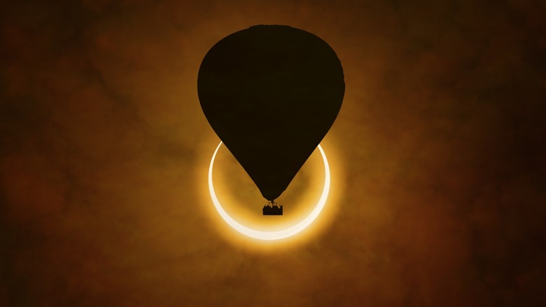 Solar eclipse with hot air balloon in front of it