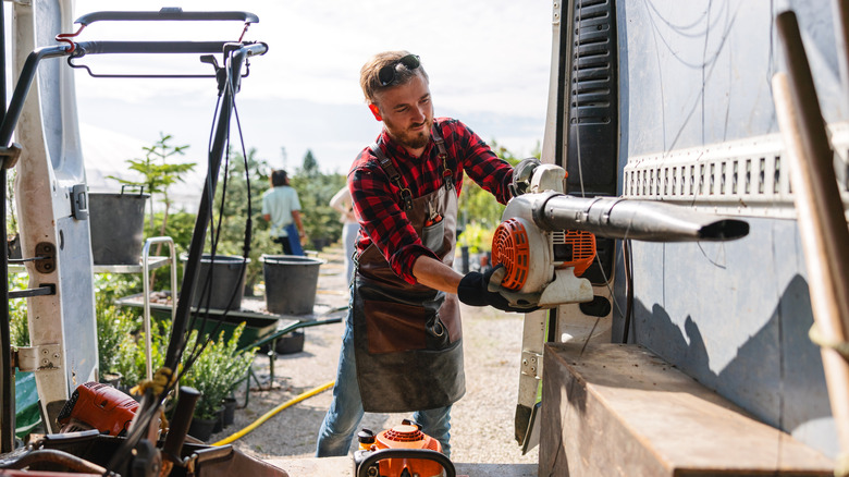 man lifting up a leaf blower