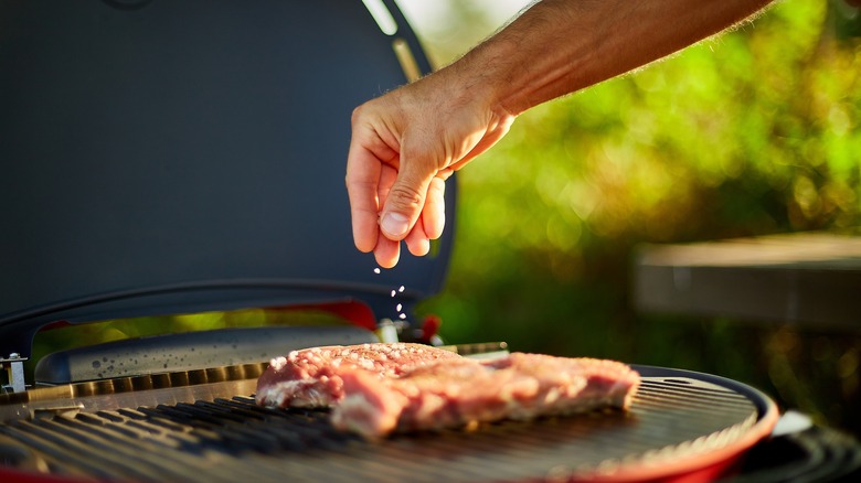 seasoning steak on grill
