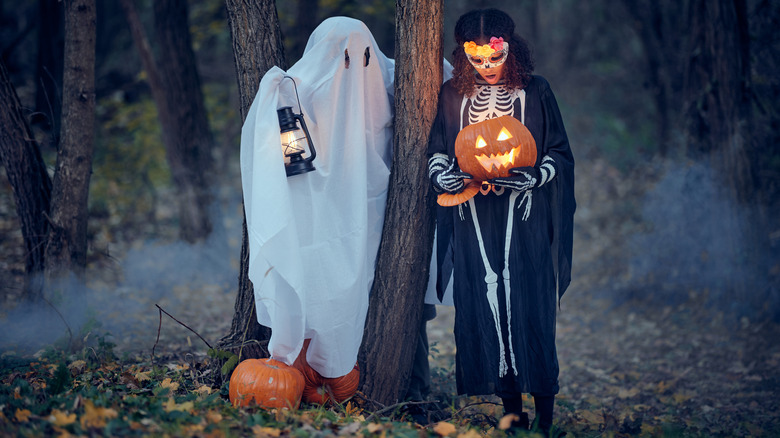 Two kids in Halloween costumes in forest