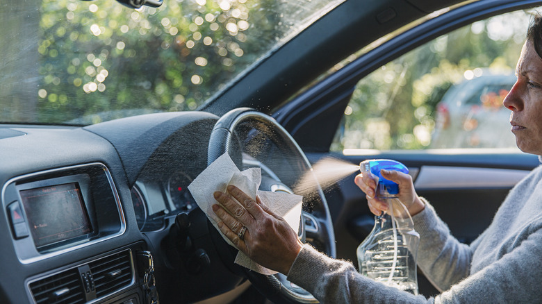 Woman driver cleaning her steering wheel