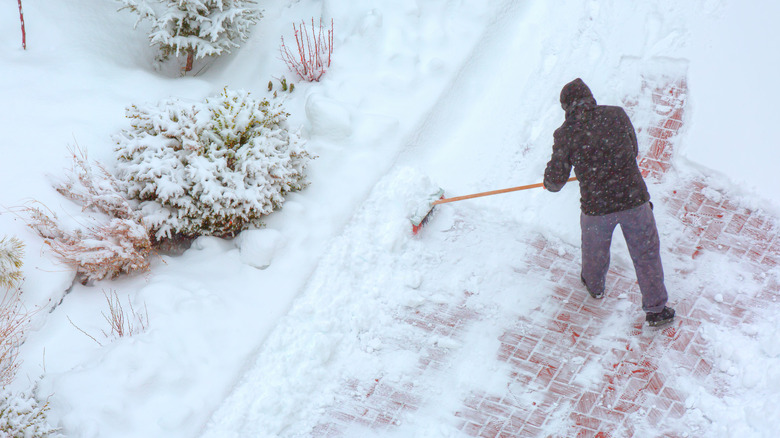 Person sweeping snow from driveway