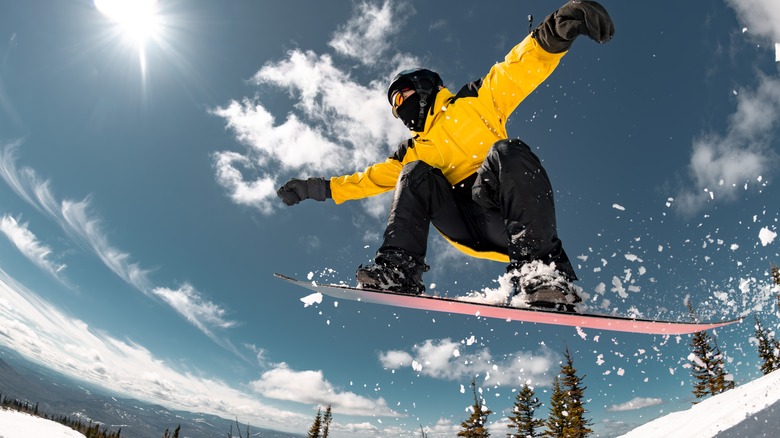 Snowboarder mid-jump over snow