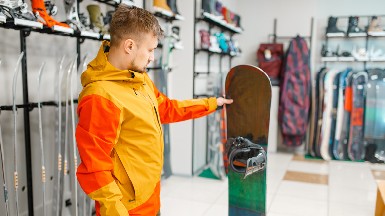 Man choosing snowboard in shop