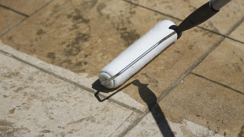 a person sealing a concrete patio