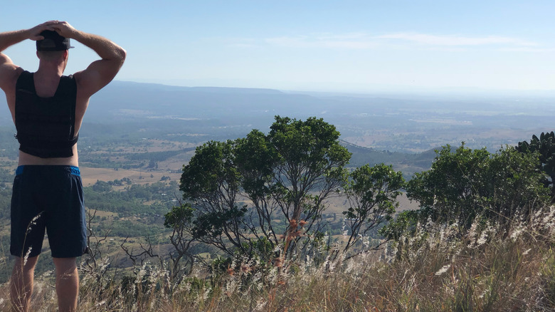 Hiker with weighted vest looking on at landscape outside