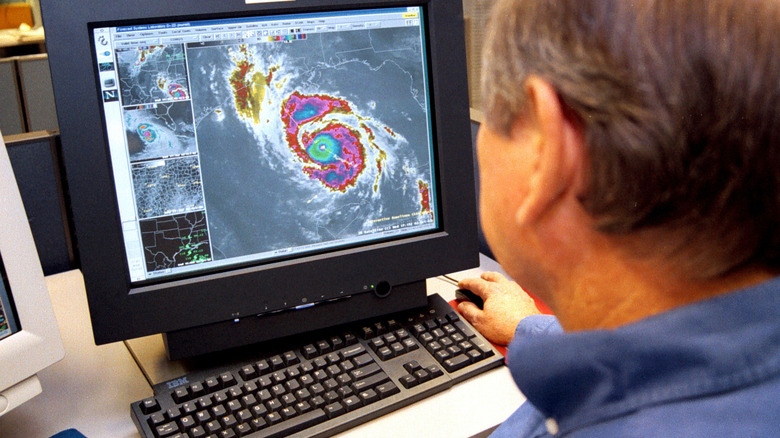 Man watching hurricane on computer