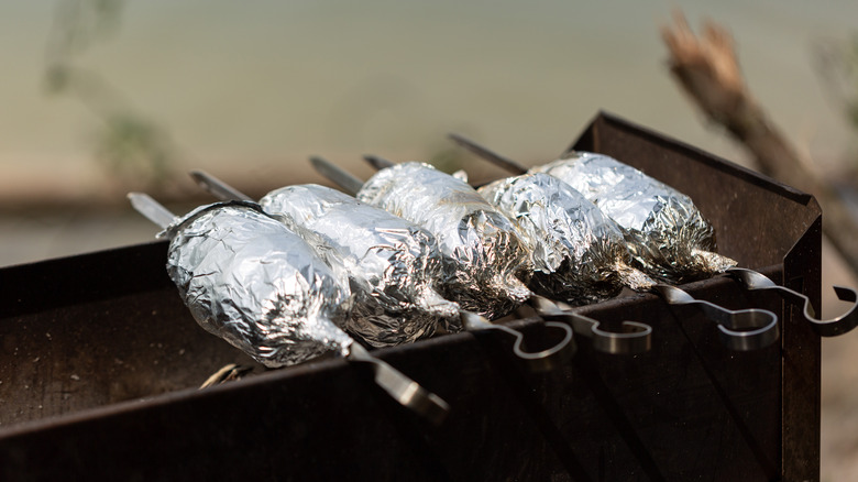 meat wrapped with aluminum foil on a bbq