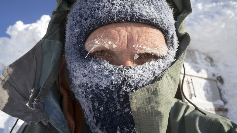 Man in balaclava covered in snow and ice