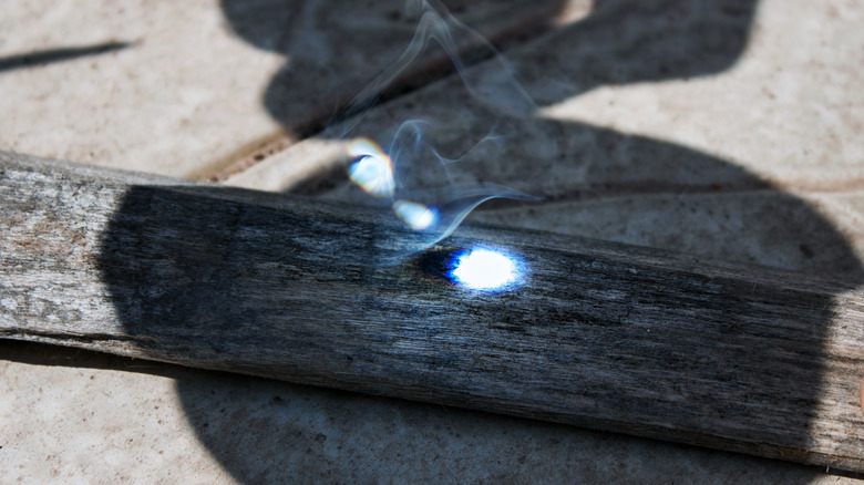 Light focused on wood to start fire