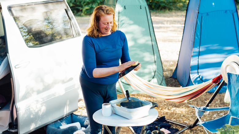 Woman washing dishes while camping