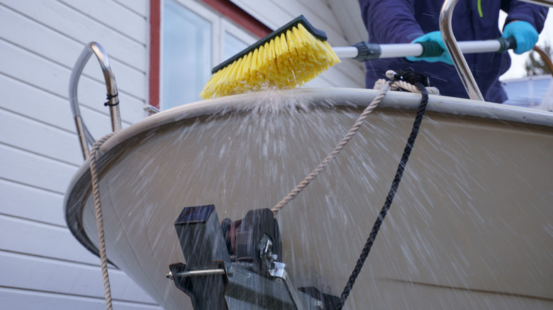 Person scrubbing and washing boat