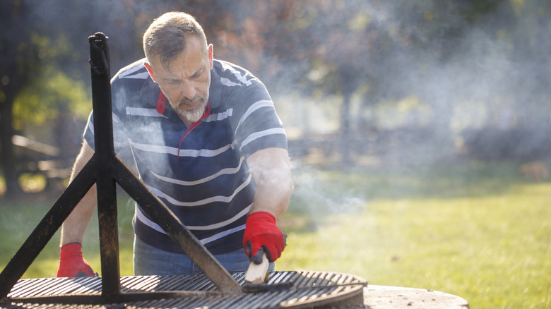 man cleaning grill