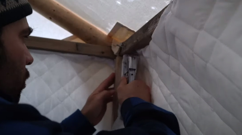 Camper hanging up wall insulation